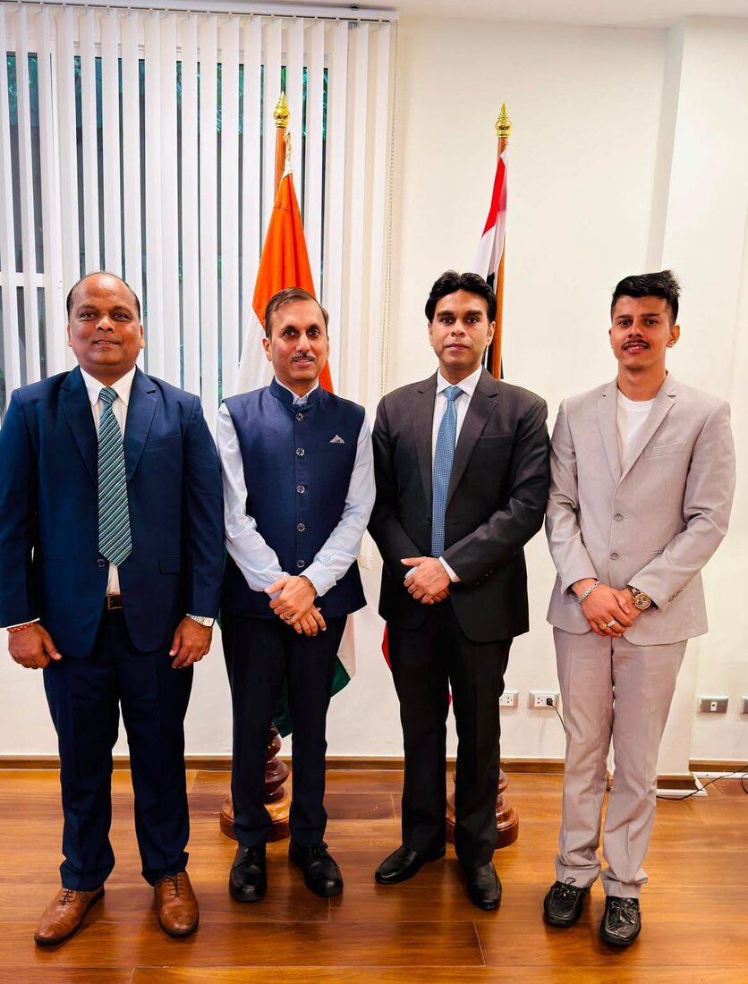 Rahul Laxman Patil, at left, with three delegation colleagues standing between the Indian national flag and a partner nation's flag at a diplomatic mission.