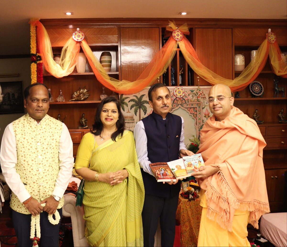 Rahul Laxman Patil, at left, at a heritage and cultural dialogue gathering where books are being presented in a decorated interior.