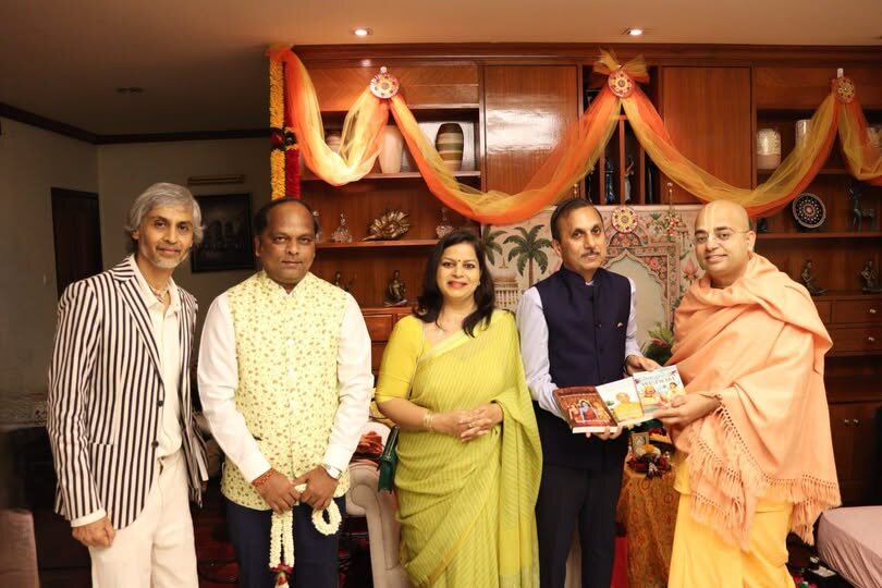 Rahul Laxman Patil with a group at a public cultural engagement in a decorated interior, with books being presented.